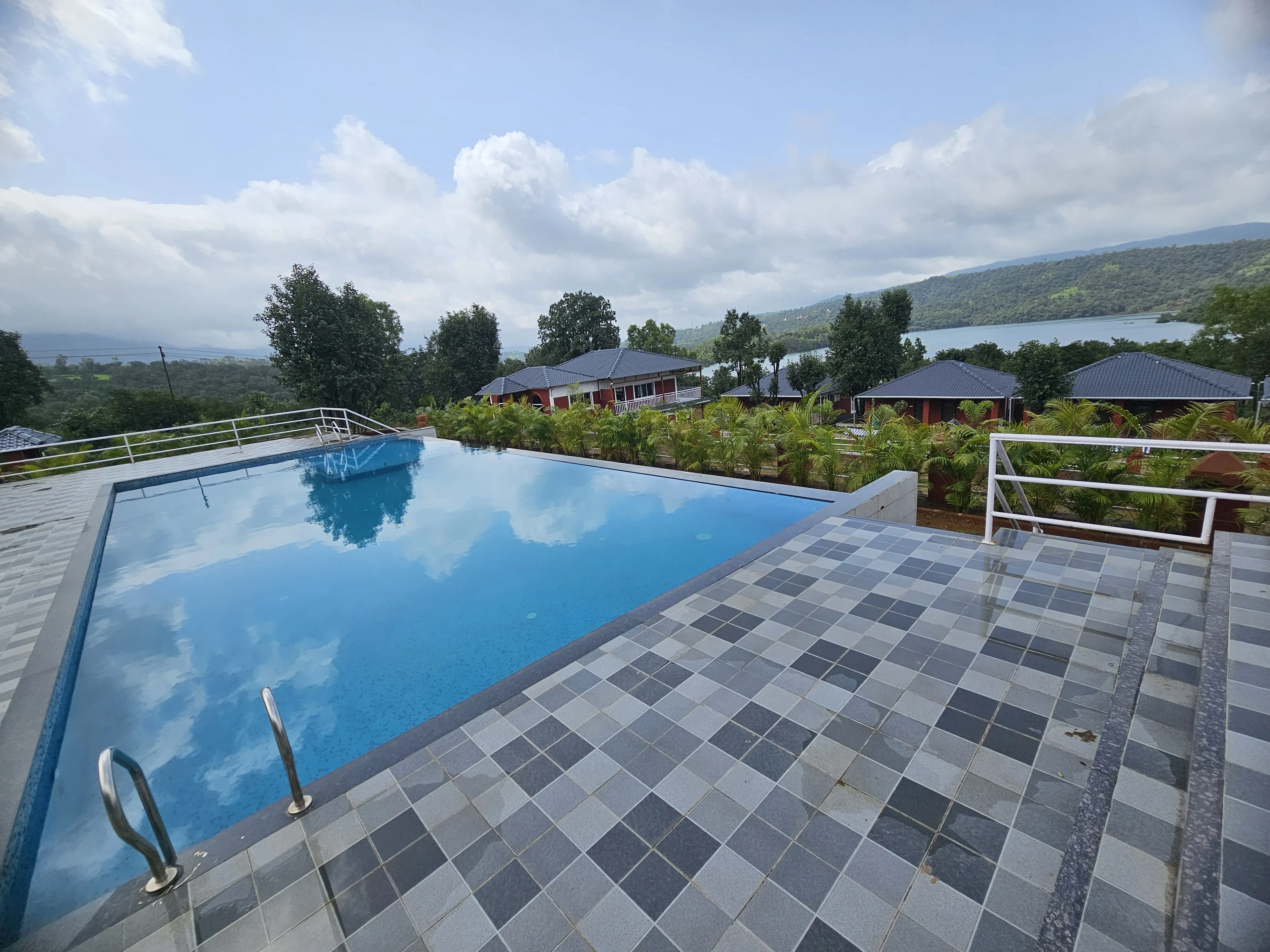 Infinity pool with scenic hill views at Aranyagiri Farmstay Resort